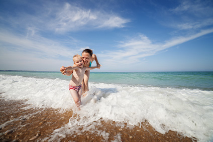 Baby mit Mutter am Strand