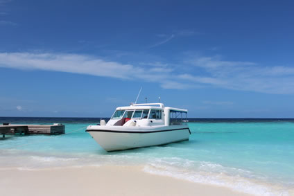 Motorboot an weißem Sandstrand auf den Malediven